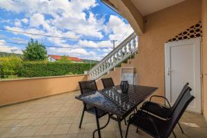 a patio with a table and chairs on a balcony at Apartments Mig in Supetarska Draga