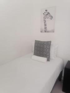 a bedroom with a bed with a giraffe picture on the wall at LaPeroge Home in Ballito