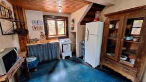 a kitchen with a white refrigerator in a room at Chalé Vista Pedra Partida in Monte Verde