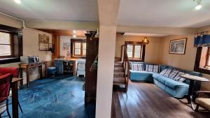 a living room with a blue couch and a kitchen at Chalé Vista Pedra Partida in Monte Verde