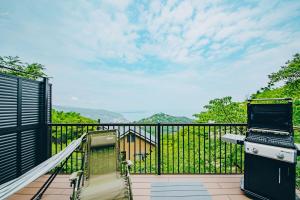 a balcony with a laptop and a grill at ItsumoYuki in Atami