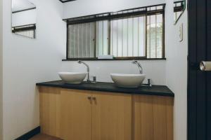 two sinks on a counter in a bathroom with a window at ItsumoYuki in Atami +60 photos