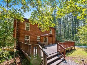 a log cabin with a deck in the woods at Log Cabin Retreat in Monroe