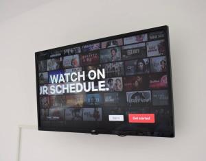 a flat screen tv sitting on top of a wall at Studio flat close to Heathrew Airport in Northolt