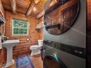 a bathroom with a toilet and a tv on the wall at Log Cabin Retreat in Monroe +33 photos