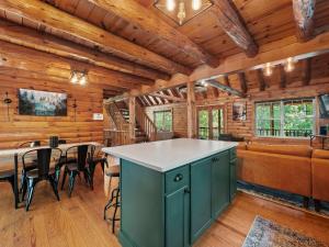 a kitchen with a large island in a room with wooden walls at Log Cabin Retreat in Monroe