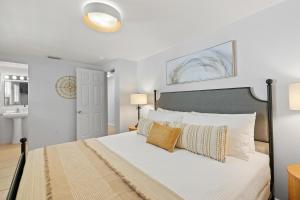 a bedroom with a bed with white sheets and pillows at Summer Lovin in Bailey Hall