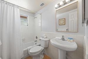 a white bathroom with a toilet and a sink at Summer Lovin in Bailey Hall +27 photos