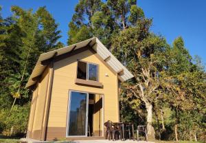 a small yellow house with chairs in front of it at Glamping Tiny house in Gachalá