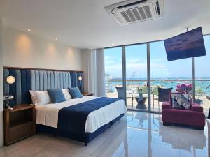 1 dormitorio con 1 cama, 1 silla y balcón en Hotel Perla Spondylus, en Manta