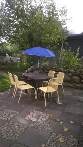 a table and chairs with a blue umbrella at Urlaub am Nord-Ostsee-Kanal in Bokelrehm +3 photos