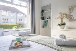 a white bedroom with a tray of food on a bed at Ashgrove House - 3 bedroom in Coatbridge