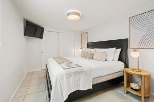 a bedroom with a large bed with white sheets at Summer Nights in Bailey Hall