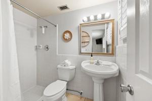 a white bathroom with a toilet and a sink at Summer Nights in Bailey Hall +27 photos