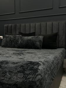 a bed with a headboard and two pillows on it at Elite BnB, High Rise with city view in Ghaziabad +31 photos