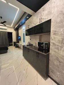 a kitchen with a sink and a microwave at Elite BnB, High Rise with city view in Ghaziabad