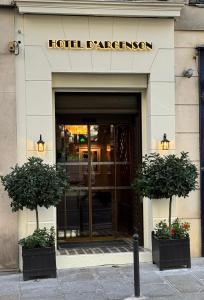 a hotel entrance with two potted plants in front of it at Hôtel d'Argenson in Paris