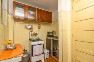 a small kitchen with a stove and a table at Condomínio Aldeia do Rádio in Carmo