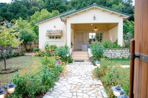 KallíthironにあるRita's Cozy Country Homeの石の歩道のある小さな白い家