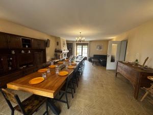 a long wooden table in a room with a kitchen at La maison Cécile 15/17 pers in Étais-la-Sauvin