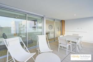 Un comedor con una mesa y sillas blancas. en Homity Holidays - Playa Granada - Mar de Fabiola, en Motril