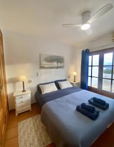 a bedroom with a bed with two blue pillows on it at Oceanview House Altea Hills in Altea la Vieja