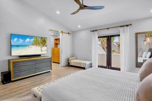 a white bedroom with a tv and a bed at Casa Blanca in Siesta Key