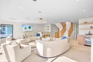 a living room with white furniture and a kitchen at Siesta Beachfront Paradise in Siesta Key