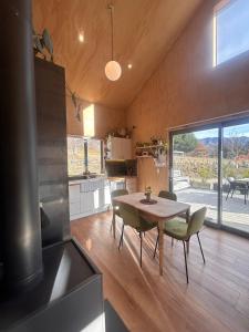 a kitchen and dining room with a table and chairs at Mountain View Barn with Spa in Queenstown