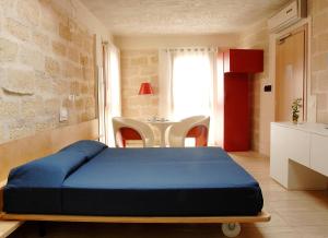 a bedroom with a bed and a dresser at Cave Bianche Hotel in Favignana