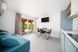 a living room with a blue couch and a table at KAPO Mobile Home in Sitno Donje