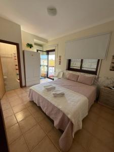 a bedroom with a large bed with two towels on it at Cici Guesthouse in Caminha
