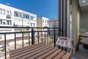 a balcony with a bench and a view of a city at Boho Style Flat with Free WiFi Near Kaleici & AVM in Antalya
