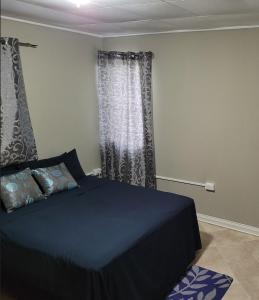 a bedroom with a blue bed and curtains at Ambridge in Saint Michael