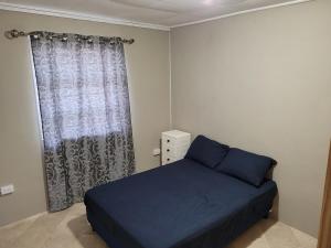 a bedroom with a blue bed and a window at Ambridge in Saint Michael