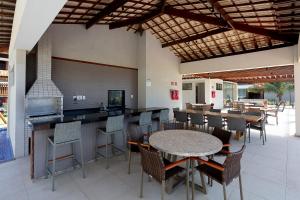 un ristorante con tavolo, sedie e un bar di Village do Mar Itacimirim pé na areia a Camassari