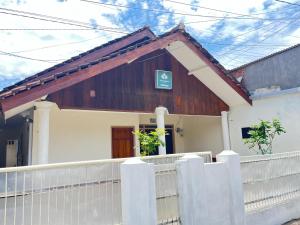 a house with a white fence in front of it at Ijen adventure house in Ketapang