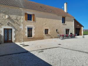 a large stone building with a patio in front of it at La maison Cécile 15/17 pers in Étais-la-Sauvin