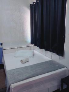 a bed in a room with a black curtain at Hot Iguaçú in Sorocaba