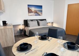 a room with a bed and a table with wine glasses at Zentrale Studio Apartments in Pforzheim
