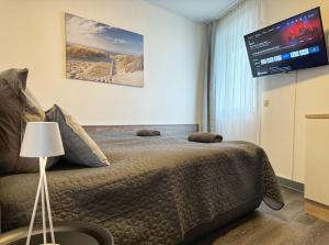 a bedroom with a bed and a flat screen tv at Zentrale Studio Apartments in Pforzheim