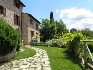 托迪Agriturismo La Torraccia的一座花园,在一座建筑前有一条石头路