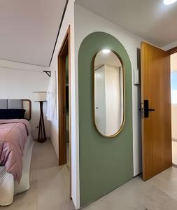une chambre avec un lit et un miroir au mur dans l'établissement Luxo Boho: Hidro, Alexa Top de linha & +, à Récife 46 autres photos