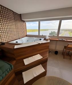 La salle de bains est pourvue d'une baignoire et d'une grande fenêtre. dans l'établissement Luxo Boho: Hidro, Alexa Top de linha & +, à Récife