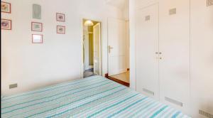 a bedroom with a bed with a blue striped blanket at Villa Paolina - INFINITYHOLIDAYS in Costa Paradiso +5 photos