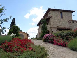 托迪Agriturismo La Torraccia的一座石头建筑，门前种着鲜花