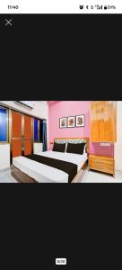 una camera con due letti e una parete rosa di Buddha Stay Inn a Varanasi