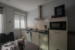 a kitchen with a counter top and a microwave at Le Petit Mona LIORA in Civaux