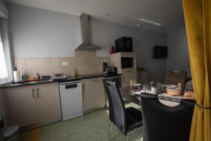 a kitchen with a table and chairs and a kitchen with a counter at Le Petit Mona LIORA in Civaux