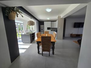 a kitchen and dining room with a wooden table and chairs at Stoepstories in Yzerfontein
